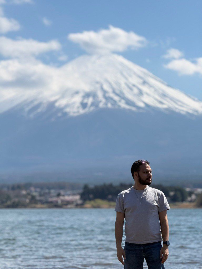 Adir at a lakeside with Mount Fuji behind him